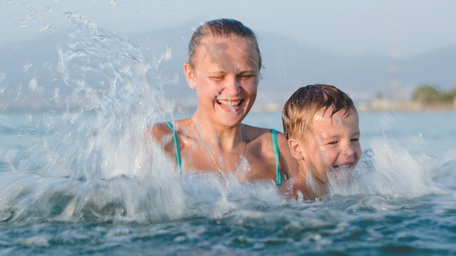 Little son and mother fooling in water