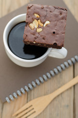 Black coffee and browny cake with notebook at morning free time