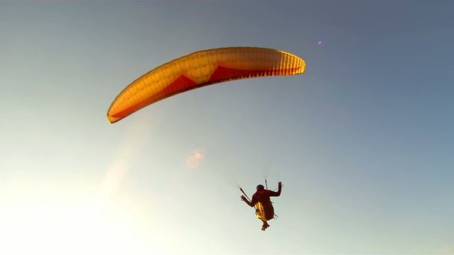 Paragliding over the mountains against blue sky