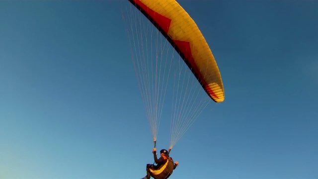 Paragliding against blue sky