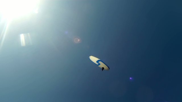 Paragliders against bright Sun