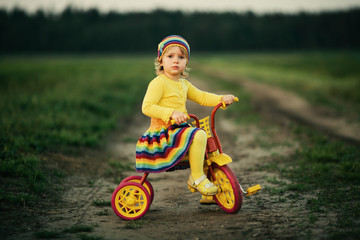 little girl biking on the road