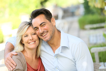 Portrait of loving mature couple relaxing on bench