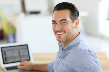 Businessman sitting in office and working on laptop
