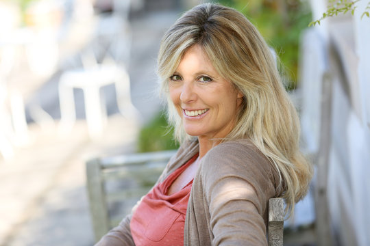 Mature Blond Woman Relaxing In Outdoor Bench