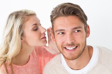 Woman whispering secret into a mans ear