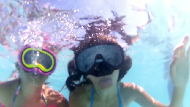 friends in a swimming pool having fun, underwater view