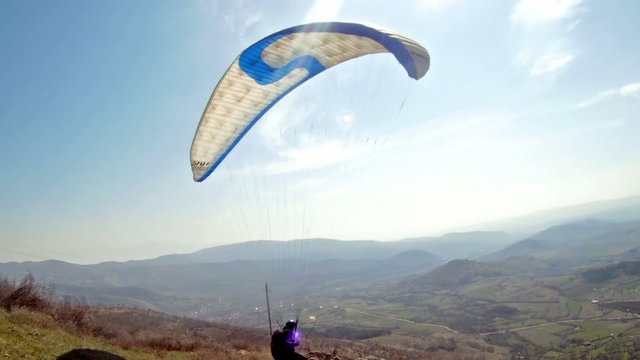 Paraglider taking off from a mountain range
