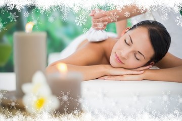 Beautiful brunette enjoying a herbal compress massage