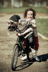 Fototapeta na wymiar little girl and boy riding on bicycle together