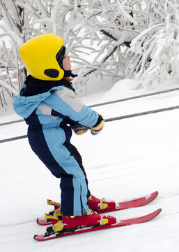 Skiing child on rope lift