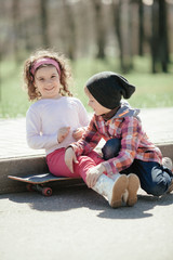 little boy and girl skaiting on the street