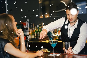 Handsome bartender serving cocktail to attractive woman