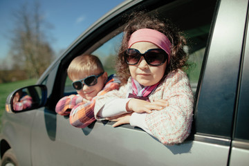 little girl and boy driving car