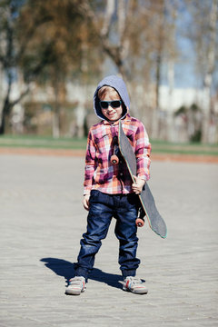 little boy with skateboard on the street