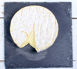 Camembert cheese on a plate slate