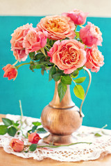 Still life with a fresh roses in a vintage jug .