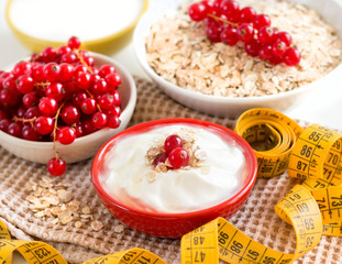 cereals with red currants,  yogurt and measuring tape