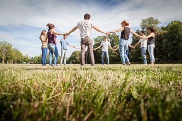 Group of friends at park holding hands. View from below