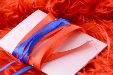 Greeting card with white paper with blue and red bow