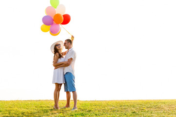 smiling couple with air balloons outdoors