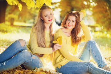 Two young girl in autumn forest