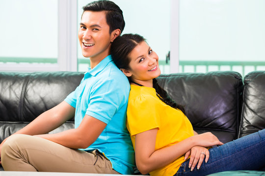 Young Asian couple on sofa or couch