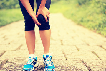  woman runner hold her sports injured knee