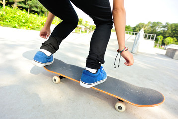 skateboarding woman legs jump at skatepark 
