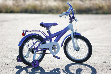 Small kids bike with training wheels outdoors.