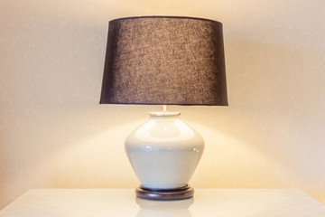 Table lamp and its shadow on wallpaper in the bedroom