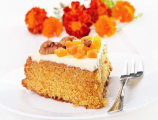 Piece of carrot cake with icing on white plate