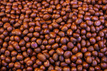 Pile of roasted chestnut for retail sale in market.