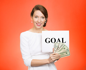businesswoman holding goal sign and money red background 