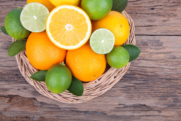 Fototapeta na wymiar Mix of fresh citrus fruits in basket on wood