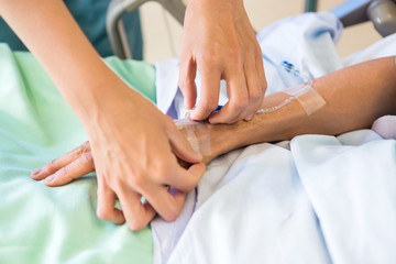 Fototapeta na wymiar Female Nurse Attaching IV Drip On Male Patient's Hand