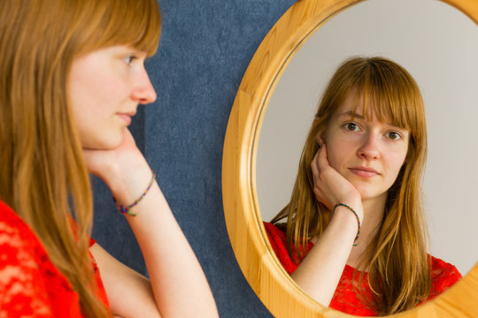 Redhead Teenage Girl Looking In Mirror