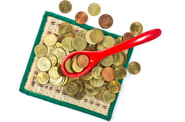 coins inside red spoon on white background