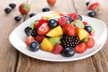 Delicious fruits salad in plate on table close-up