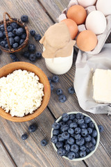 Fresh blueberries and milk products on wooden table