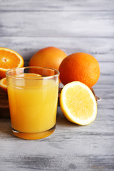 Obraz na płótnie Canvas glass of juice with fresh fruits on grey wooden table