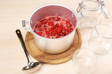Cooking delicious strawberry jam in kitchen