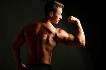 Handsome muscle young man on dark background