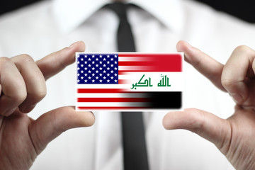 Businessman holding a business card with USA and Iraq Flag