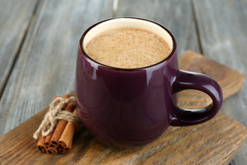 Milk with cinnamon on wooden table