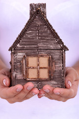 Woman hands holding small house close up