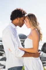 Gorgeous couple embracing by the coast