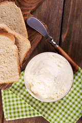 Fresh homemade butter in bowl and sliced bread,