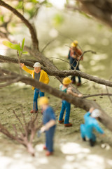Miniature workmen clearing fallen trees