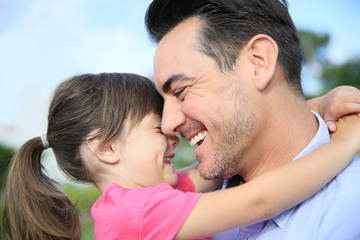 Fototapeta premium Portrait of little girl hugging her daddy